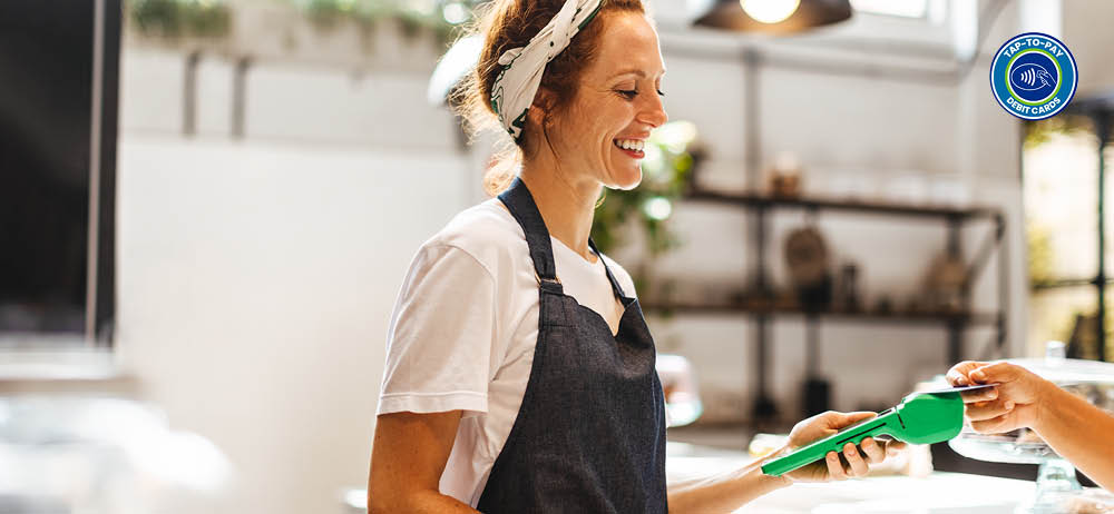 tap-to-pay-debit-cards cashier-taking-tap-to-pay-payment