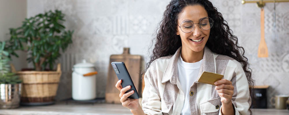 rivers-edge-bank-debit-cards woman-holding-debit-card-and-phone