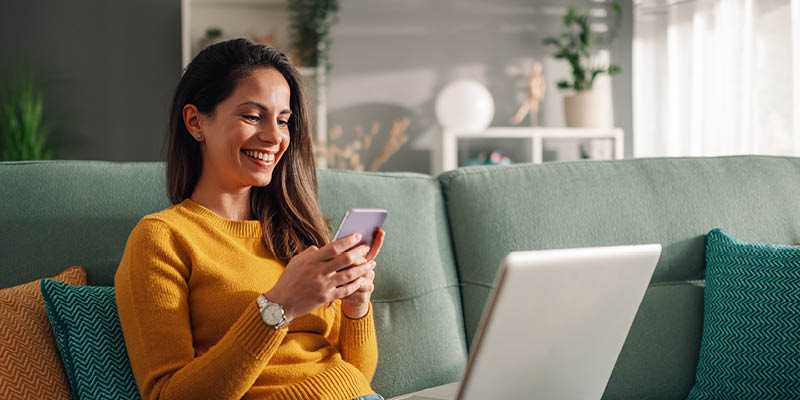 women-in-yellow-mobile-banking-app woman-yellow-sweater-on-phone